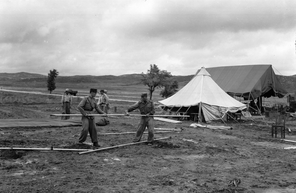North Korean soldiers building a tent in bean field